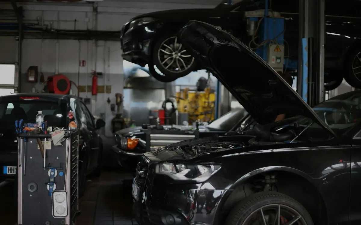 Fekete Audi felnyitott motorháztetővel egy európai szervizben