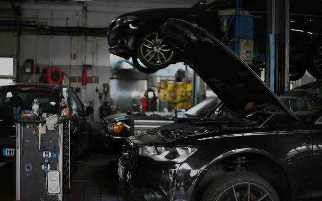Fekete Audi felnyitott motorháztetővel egy európai szervizben